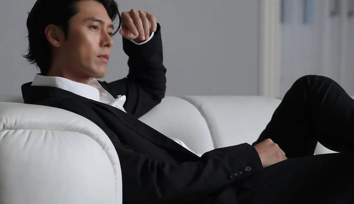 Setelan jas warna hitam itu dipadukan dengan kemeja putih [instagram/vast.ent]