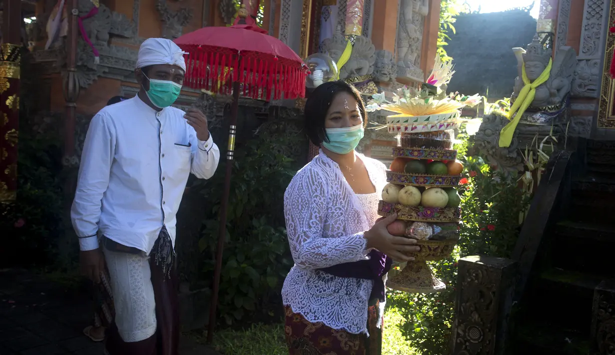 Umat Hindu membawa sesajen saat Hari Raya Galungan di sebuah pura di Bali, Rabu (14/4/2021). Perayaan Hari Raya Galungan yang merupakan hari kemenangan kebenaran (Dharma) atas kejahatan (Adharma) itu diikuti umat Hindu di Bali dengan menerapkan protokol kesehatan. (AP/Firdia Lisnawati)