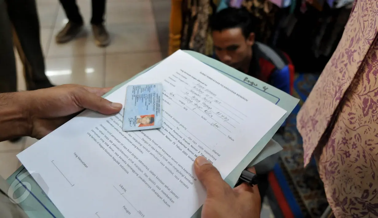 Petugas mendata pengunjung yang melakukan pelanggaran karena meroko di tempat umum , Jakarta, Rabu (3/6/2015).  Atas kejadian ini Pemprov DKI Jakarta  memberikan peringatan pertama pada pengelola Mal. (Liputan6.com/Johan Tallo)