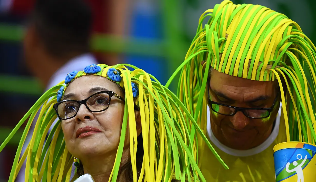 Pendukung tim Brasil menggunakan wig unik saat menyaksikan pertandingan bola tangan putri antara Spanyol vs Norwegia dalam ajang Olimpiade 2016, di Rio de Janeiro, 8 Agustus 2016. (AFP PHOTO/Franck FIFE)