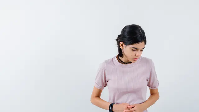 Perempuan Memegang Perutnya yang Sakit