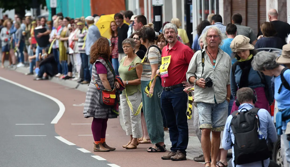 Sejumlah demonstran bersiap ambil bagian membentuk rantai manusia untuk menuntut penutupan reaktor nuklir di Aachen, Jerman barat, 25 Juni 2017. Aksi rantai manusia ini melintasi wilayah tiga negara, Jerman, Belgia dan Belanda. (Henning Kaiser/dpa via AP)