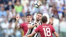 Aksi pemain Juventus, Miralem Pjanic menyundul bola melewati dua pemain Cagliari pada laga Serie A di  Turin, (19/8/2017). Juventus menang 3-0. (Alessandro Di Marco/ANSA via AP)