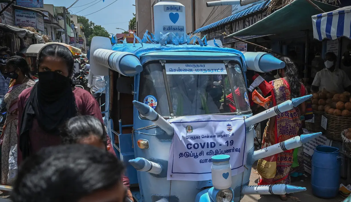 Sebuah bajaj yang dihias dengan replika jarum suntik besar melintasi jalanan di Chennai, India, Sabtu (3/6/2021). Seorang seniman di Chennai menghias bajaj tersebut untuk meningkatkan kesadaran orang-orang tentang pentingnya vaksinasi Covid-19 di tengah sejumlah temuan varian baru. (Arun SANKAR/AFP)