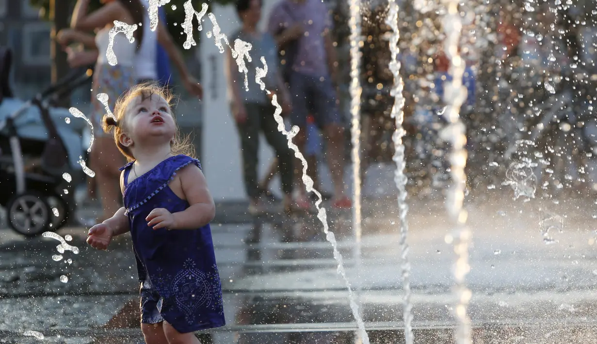 Seorang anak kecil melihat air mancur saat bermain dan menikmati musim panas di taman Gorky, Moskow, Rusia, Minggu (9/8/2015). (REUTERS/Sergei Karpukhin)
