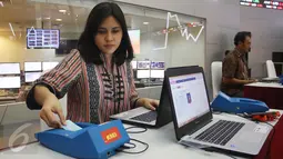 Petugas memasukan data dari e-KTP menggunakan alat pembaca kartu atau card reader e-KTP di Jakarta, Kamis (6/4). Alat ini dapat mempermudah proses pembukaan rekening investor di pasar modal. (Liputan6.com/Angga Yuniar)