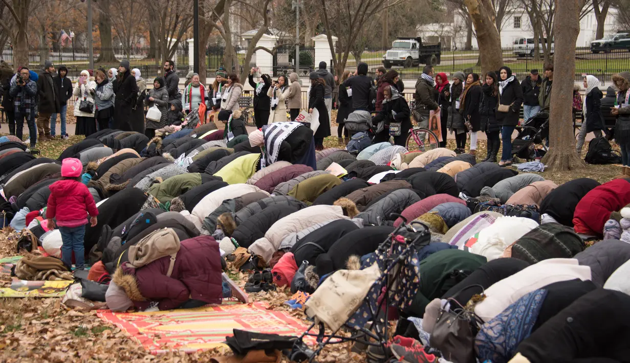 Warga Muslim melaksanakan Salat Jumat berjamaah di depan Gedung Putih, Washington DC, Amerika Serikat (AS), Jumat (8/12). Para warga muslim ini memprotes keputusan Presiden AS Donald Trump mengakui Yerusalem sebagai ibu kota Israel. (mari matsuri / AFP)