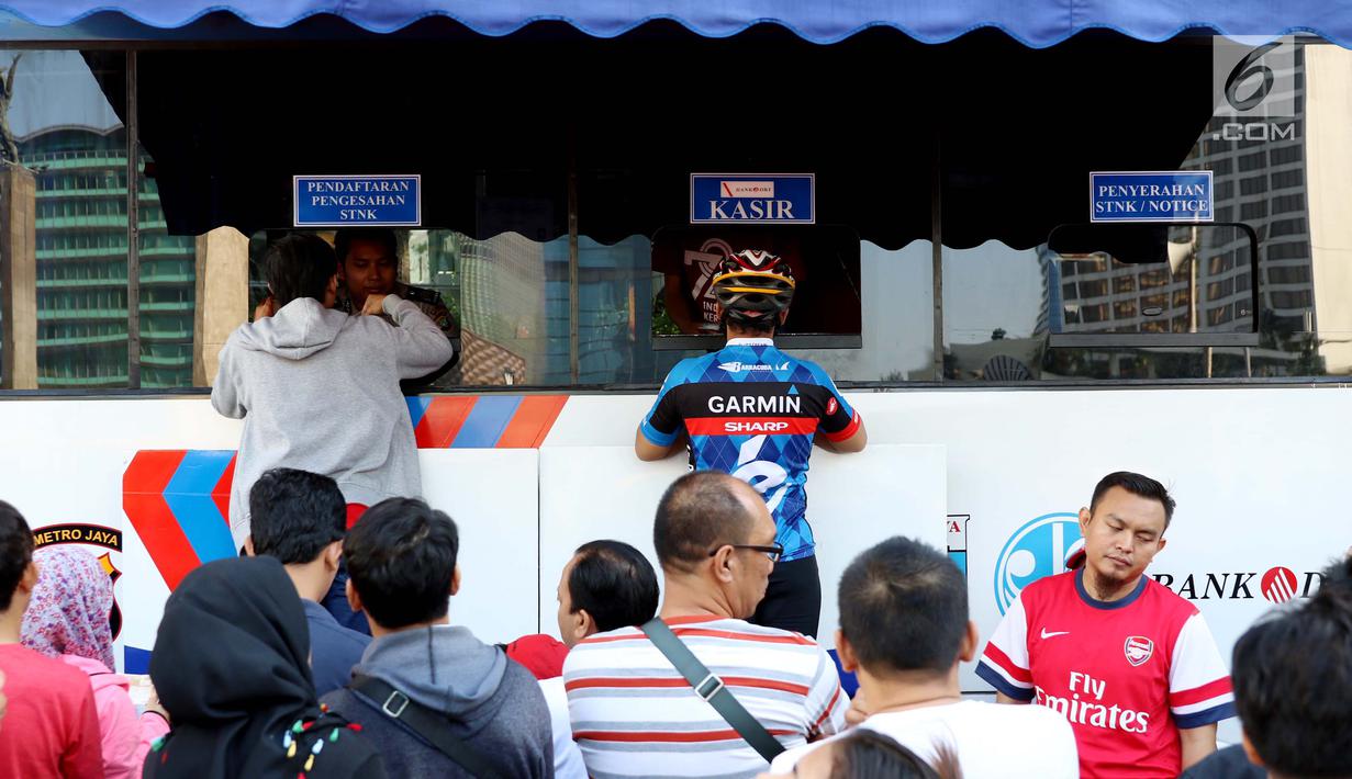 Warga membayar pajak kendaraan bermotor di samsat keliling di car free day, Jakarta, Minggu (27/8). Layanan pembayaran pajak Surat Tanda Nomor Kendaraan (STNK) bisa dilakukan tanpa membawa salinan atau BPKB. (Liputan6.com/Angga Yuniar)