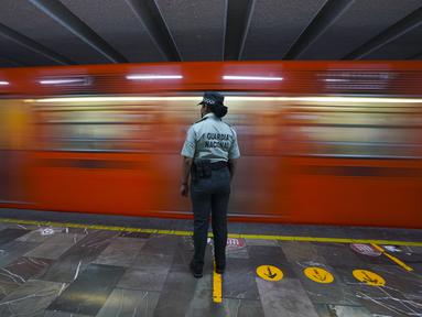 Seorang anggota Garda Nasional Meksiko berjaga di stasiun kereta bawah tanah kota di Mexico City, Kamis (12/1/2023). Wali Kota Mexico City mengatakan lebih dari 6 ribu petugas Garda Nasional akan ditempatkan di sistem kereta bawah tanah kota setelah serangkaian kecelakaan yang menurut para pejabat bisa jadi karena sabotase. (AP Photo/Fernando Llano)