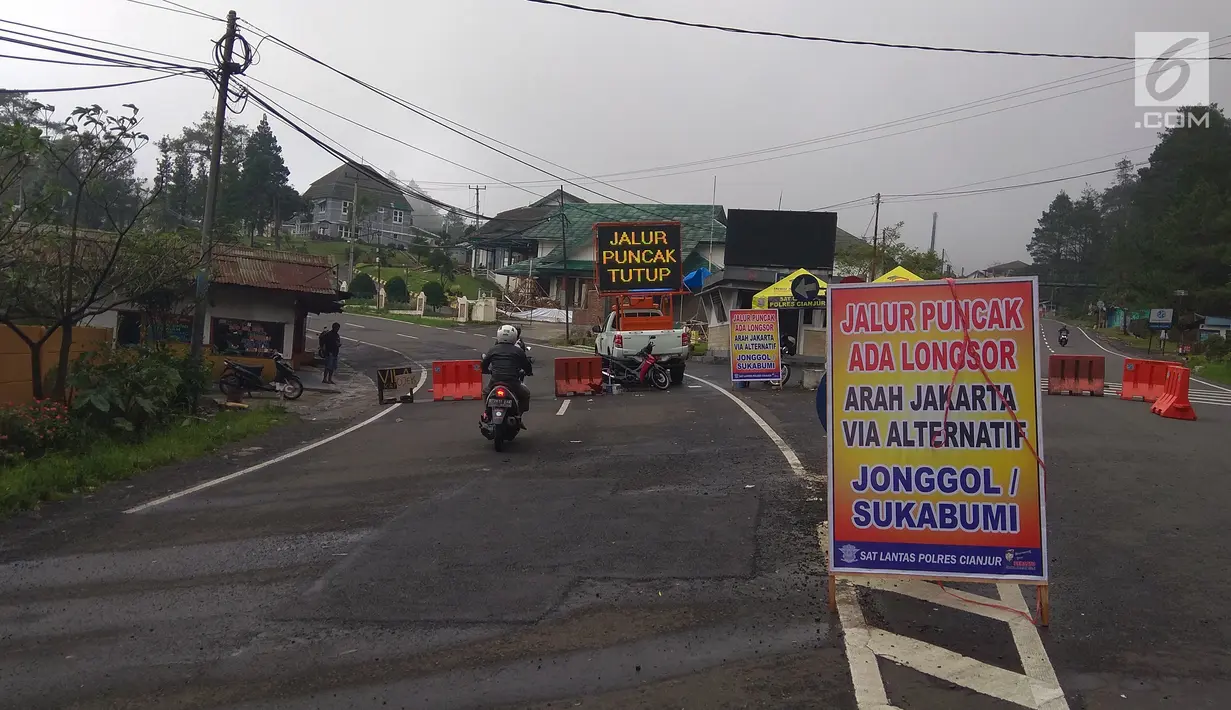 Papan penutupan arus lalu lintas terpasang di jalan Cimacan, Kabupaten Cianjur, Jawa Barat, Rabu (14/2). Setelah ditutup sejak 5 Februari lalu karena longsor, kawasan puncak Bogor sampai Cianjur menjadi seperti kota mati. (Liputan6.com/Achmad Sudarno)