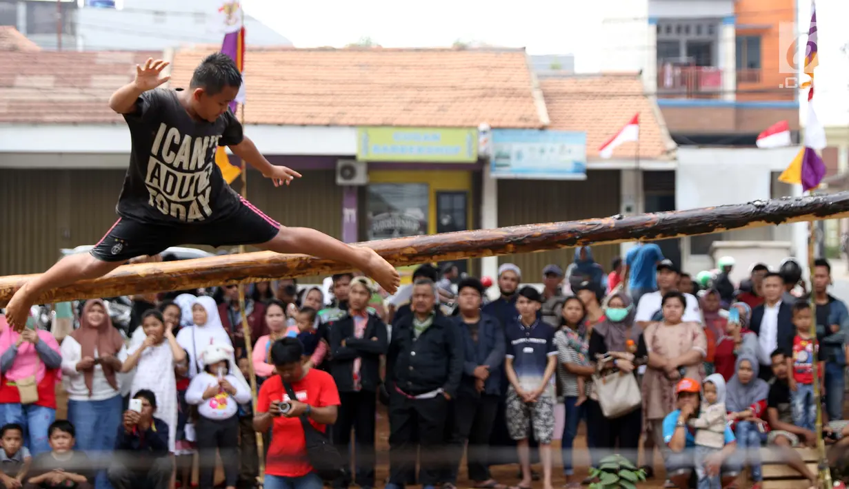 Anak-anak bermain lomba jalan di atas batang pohon pinang di sekitar Kalimalang, Jakarta, Sabtu (17/8/2019). Beragam lomba permainan digelar warga untuk menyemarakkan HUT ke-74 Republik Indonesia. (Liputan6.com/Helmi Fithriansyah)