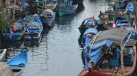 Perahu dan kapal nelayan dengan alat tangkap cantrang bersandar di Kompleks Perumahan Pesisir Sentolo Kawat, Cilacap, Jawa Tengah. (Liputan6.com/Muhamad Ridlo)