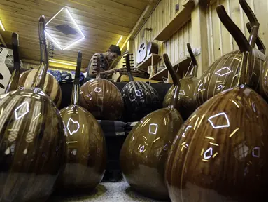 Seorang pekerja menyelesaikan pembuatan alat musik Oud di sebuah rumah produksi di Damaskus, Suriah (17/7). Oud adalah alat musik yang mirip gitar yang berasal dari Afrika Utara dan Timur Tengah. (AFP Photo/Louai Beshara)