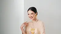 Raline Shah mengenakan kebaya encim berwarna cream dengan bordiran bunga ungu dipadukan dengan kain batik nuansa kuning-ungu. [Instagram/ralineshah]