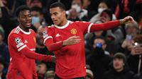 Mason Greenwood (kanan) menjadi pemain termuda kedua yang mampu mencetak gol di Liga Champions 2021/2022. Ia tercatat mamu mencetak 1 gol dan 1 assist dari empat penampilannya bersama Manchester United di umurnya yang masih 20 tahun. (AFP/Paul Ellis)