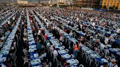 Warga Lebanon beserta yatim piatu dan pengungsi Suriah  berkumpul di sekitar meja-meja Iftar di Beirut Waterfront, Lebanon (9/6). Sebuah organisasi amal Lebanon menggelar buka puasa Ramadan dengan meja terpanjang di dunia. (AP Photo / Hussein Malla)