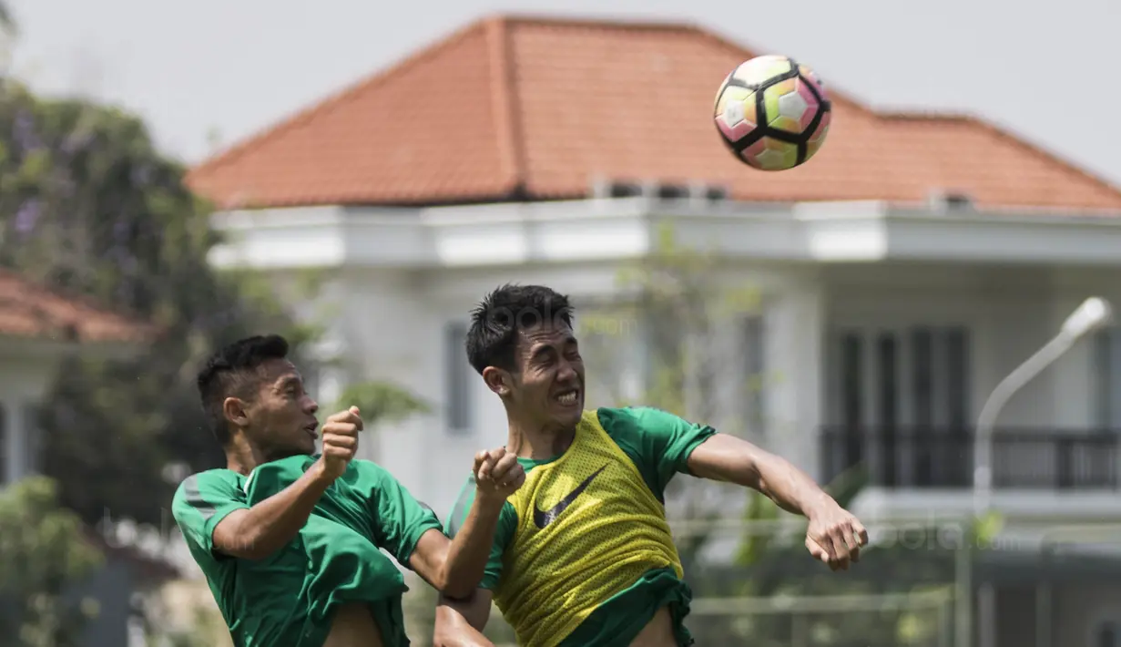 Pemain Timnas Indonesia U-22, Ryuji Utomo, duel udara dengan Andy Setyo, saat latihan di Lapangan SPH Karawaci, Banten, Kamis (10/8/2017). Latihan dilakukan sebagai persiapan jelang SEA Games 2017 Malaysia. (Bola.com/Vitalis Yogi Trisna)