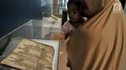 Pengunjung melihat salah satu koleksi mushaf Alquran yang dipamerkan di Museum Bayt Al-Quran, Jakarta, Minggu (19/5/2019). Puluhan mushaf Alquran yang berada di Bayt Al-Quran  dikumpulkan sejak abad ke-16. (merdeka.com/Iqbal Nugroho)