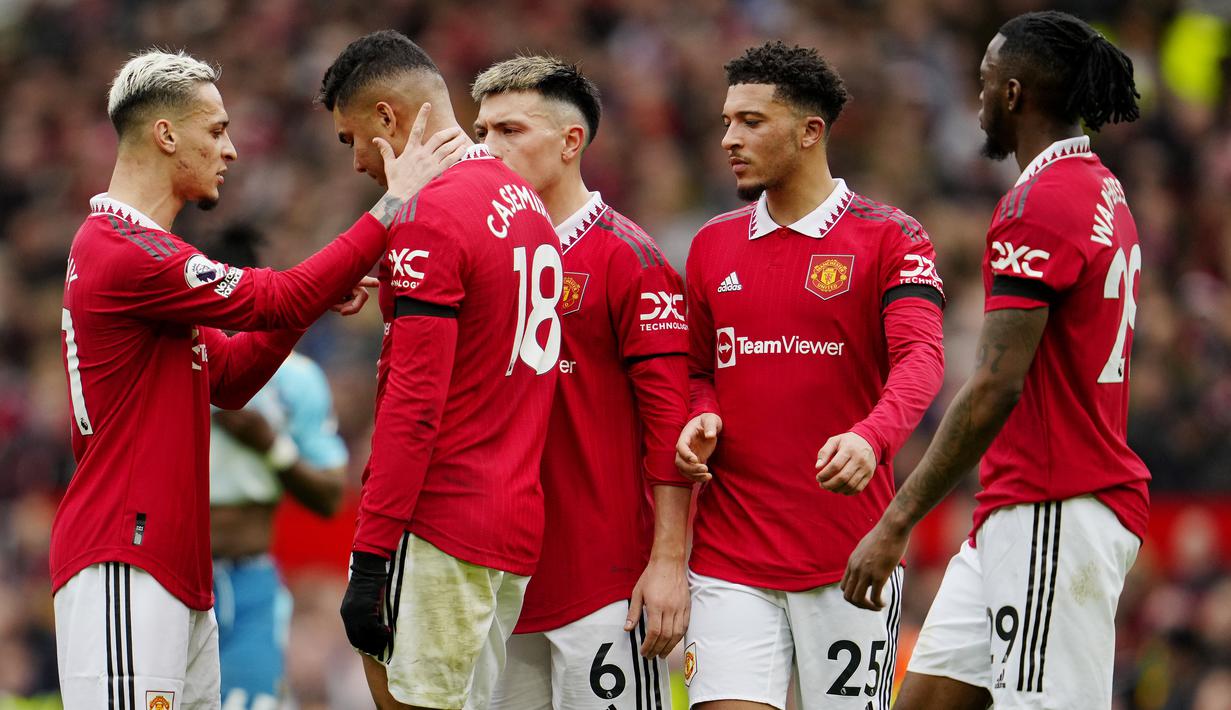 Para pemain Manchester United berusaha menenangkan Casemiro setelah mendapat kartu merah pada laga Liga Inggris di Stadion Old Trafford, Minggu (12/3/2023). (AP Photo/Jon Super)