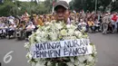 Seorang Pengunjuk rasa membawa karangan bunga saat menggelar aksi longmarch menuju Istana Merdeka, Jakarta, Senin (9/11/2015). Mereka menolak RPP tentang rumah negara PP NO 40 tahun 94 & PP No. 31 Tahun 2005. (Liputan6.com/Faizal Fanani)