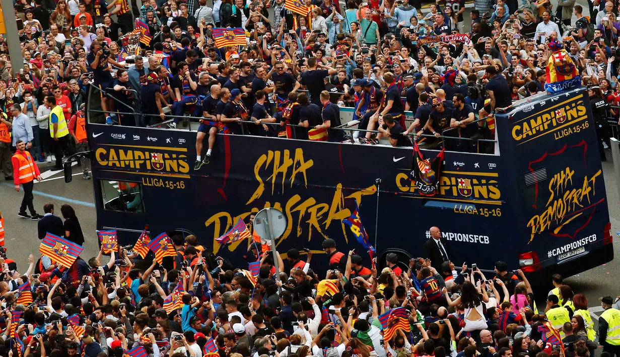 Sejumlah pemain dan staf Barcelona saat merayakan juara Liga Spanyol yang ke-24 diatas bus terbuka di sepanjang jalan Barcelona , Spanyol , 15 Mei 2016. Barcelona memastikan gelar juara setelah menang 3-0 atas Granada. (REUTERS / Albert Gea)