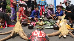 Sejumlah petani Kendeng membagi makanan saat aksi di depan Istana Negara, Jakarta, Kamis (2/8). Dalam aksinya, petani Kendeng melakukan tradisi Brokohan atau makan bersama nasi aneka urap yang sebelumnya didoakan. (Liputan6.com/Helmi Fithriansyah)