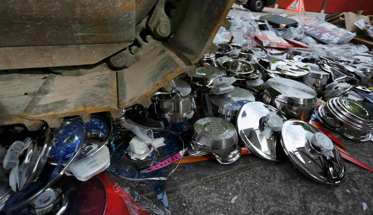 Panci palsu dan peralatan dapur yang dihancurkan menggunakan alat berat di Jenewa, Swiss, Selasa (16/6/2015). Peralatan masak palsu tersebut disita selama dua tahun terakhir dari para pelaku penyelundup. (REUTERS/Pierre Albouy)