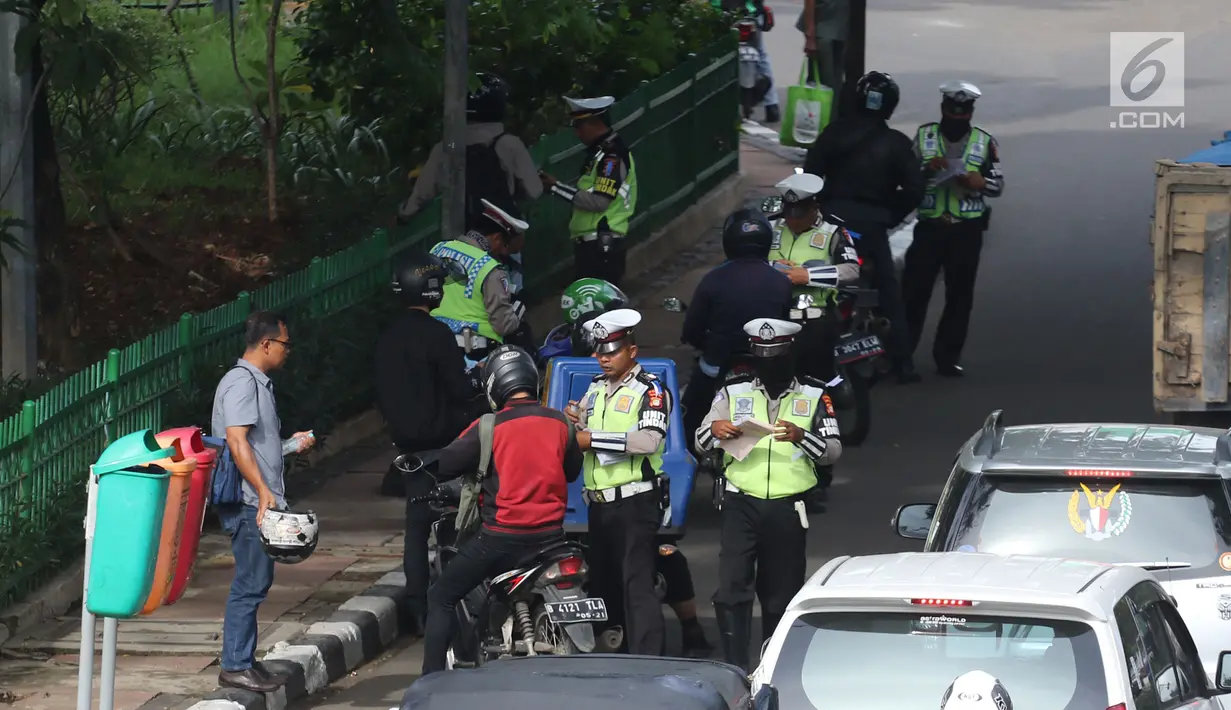 Petugas kepolisian memeriksa kelengkapan surat-surat pengendara bermotor saat Operasi Keselamatan Jaya 2018  di Jalan Letjen Suprapto, Jakarta, Senin (5/3). Dalam operasi hari pertama, Polda Metro menerjunkan 2.704 personel. (Liputan6.com/Arya Manggala)