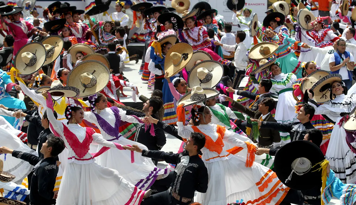 Pasangan menari mengikuti irama musik tradisional mariachi untuk memecahkan Rekor Dunia Guinness di Guadalajara, Meksiko pada 24 Agustus 2019. Sebanyak 882 orang menari dengan kostum tradisional dalam upaya memecahkan rekor dunia untuk kategori tarian rakyat terbesar. (ULISES RUIZ/AFP)