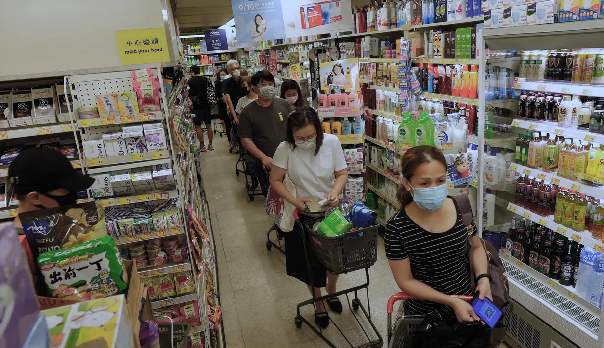 Orang-orang membeli makanan di supermarket untuk persiapan menghadapi Badai Tropis Kompasu di Hong Kong pada Selasa (12/10/2021). Observatorium Hong Kong mengeluarkan sinyal nomor 8, level tertinggi ketiga dalam skalanya, saat siklon tropis Kompasu semakin mendekati kota. (AP Photo/Vincent Yu)