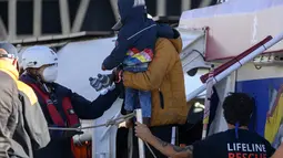 Para migran turun dari kapal kemanusiaan Jerman Rise Above berlabuh di kota pelabuhan Italia selatan Reggio Calabria, Selasa (8/11/2022). Kelompok kemanusiaan Jerman Mission Lifeline mengatakan kapalnya berlabuh di Italia selatan Selasa pagi dan menurunkan 89 orang yang telah diselamatkannya di Mediterania tengah. (AP Photo/Valeria Ferraro)
