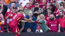 Pemain Liverpool, Mohamed Salah mengambil gawai dari salah satu suporter timnya untuk berswafoto setelah mencetak gol ke gawang Tottenham Hotspur dalam laga lanjutan Liga Inggris 2024/2025 di Anfiled, Liverpool, Inggris, Minggu (27/04/2025) waktu setempat. (AP Photo/Jon Super)