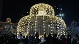 Orang-orang berkumpul di sekitar dekorasi Natal yang diterangi lampu pada Malam Natal di Seoul, Korea Selatan, Jumat (24/12/2021). (AP Photo/Ahn Young-joon)