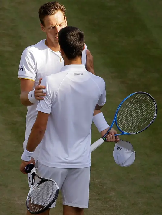 Petenis Serbia, Novak Djokovic  dan Tomas Berdych (Ceko) berbincang usai mengundurkan diri pada perempatfinal Wimbledon 2017, Rabu (12/7). Tak kuasa menahan sakit, Djokovic menyerah pada set kedua saat posisi tertinggal 6-7 (2), 0-2. (AP/Alastair Grant)