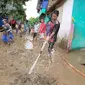 Beberapa warga terdampak banjir bandang pesisir pantai selatan Garut, Jawa Barat terlihat tengah melakukan kerja bakti membersihkan lumpur sisa banjir. (Liputan6.com/Jayadi Supriadin)