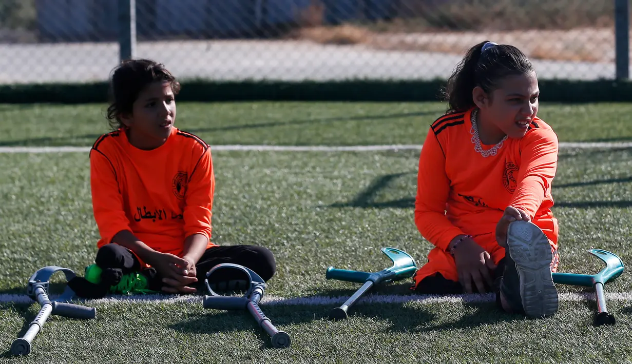 Anak-anak Palestina yang diamputasi berpartisipasi dalam sesi pelatihan sepak bola, yang diatur oleh Komite Palang Merah Internasional (ICRC) setelah pembatasan penyakit coronavirus (COVID-19) mereda, di Deir al-Balah di Jalur Gaza tengah (14/7/2020). (AFP/Mahmud Hams)