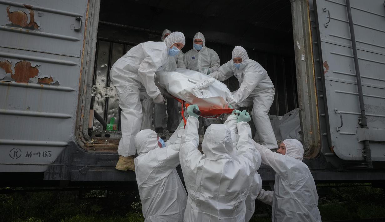 Prajurit Ukraina memasukkan jenazah-jenazah tentara Rusia, yang dikumpulkan setelah pertempuran di wilayah Kiev dan Chernihiv, ke dalam gerbong kulkas kereta api di Kiev, Ukraina pada 13 Mei 2022. Jasad tentara Rusia tersebut dikumpulkan setelah pertempuran di wilayah Kiev dan Chernihiv. Kepala Kerja Sama Sipil-militer Ukraina, Volodymr Lyamzin, mengatakan negaranya bertindak sesuai dengan hukum internasional dan siap untuk mengembalikan jasad-jasad itu ke Rusia. (AP Photo/Efrem Lukatsky)