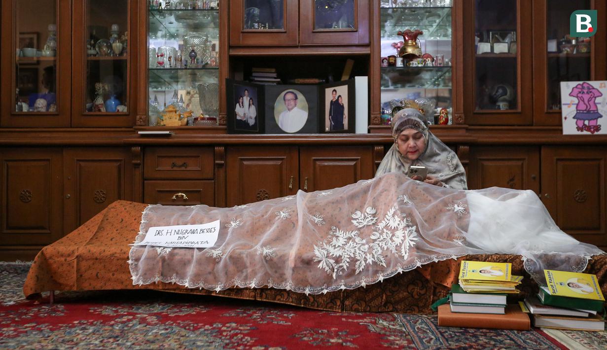 Salah satu anggota keluarga mendoakan mendiang mantan Sekjen PSSI, Nugraha Besoes yang terletak di Perumahan Alfa Indah Blok A II No.18 Joglo, Jakarta Barat, Senin (06/02/2023). Nugraha Besoes meninggal dunia pada Senin (06/02/2023) pukul 00.19 WIB di RS PON. (Bola.com/Bagaskara Lazuardi)