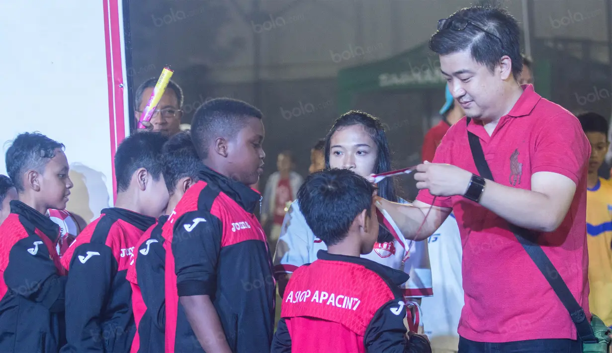 GM Sales & Marketing KMK Online, Edwin Kartawinata, mengalungkan medali kepada pemain ASIOP Apacinti usai meraih gelar Liga Bola Indonesia. (Bola.com/Vitalis Yogi Trisna)