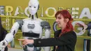 Seorang wanita berpose disamping robot InMoov rancangan Gael Langevin dalam pameran teknologi Bucharest, Romania (26/5). Robot ini dirancang berdasarkan gagasan tangan palsu buatan Langevin yang dikembangkan pada tahun 2011. (AP Photo / Vadim Ghirda)