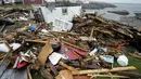 Seorang penduduk dan pekerja pencarian dan penyelamatan memeriksa sisa-sisa rumah yang hancur di Port aux Basques, Newfoundland dan Labrador, Senin, 26 September 2022. Di seberang Maritimes, Quebec timur dan di barat daya Newfoundland, dampak ekonomi dari murka badai Fiona adalah masih dihitung. (Frank Gunn/The Canadian Press via AP)