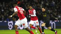 Aksi bintang PSG, Lionel Messi saat mencoba melewati pemain Reims dalam laga Ligue 1 2022/2023 di Parc des Princes, Senin (30/1/2023). (AP Photo/Thibault Camus)