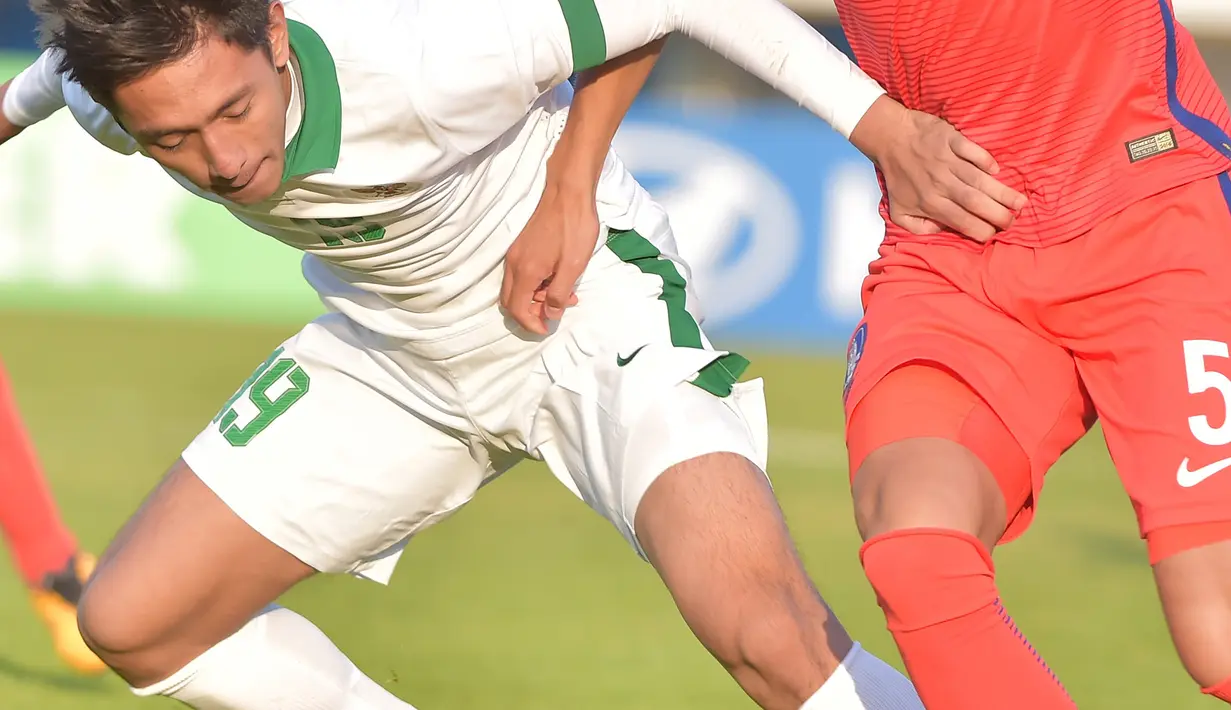 Pemain depan Timnas Indonesia U-19, Hanis Saghara Putra berebut bola dengan pemain Korsel Kim Hyunwoo pada laga ketiga kualifikasi Piala Asia U-19 2018 di Paju Public Stadium, Korsel (4/11). Timnas kalah 4-0 dari Korsel. (AFP Photo/Kim Doo-Ho)