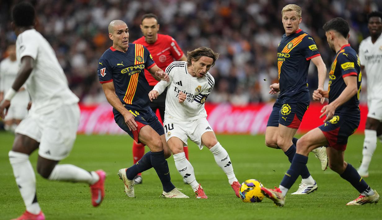Pemain Real Madrid, Luka Modric berusaha melewati penjagaan sejumlah pemain Girona dalam laga lanjutan Liga Spanyol 2024/2025 di Stadion Santiago Bernabeu, Madrid, Minggu (24/02/2025) waktu setempat. (AP Photo/Manu Fernandez)