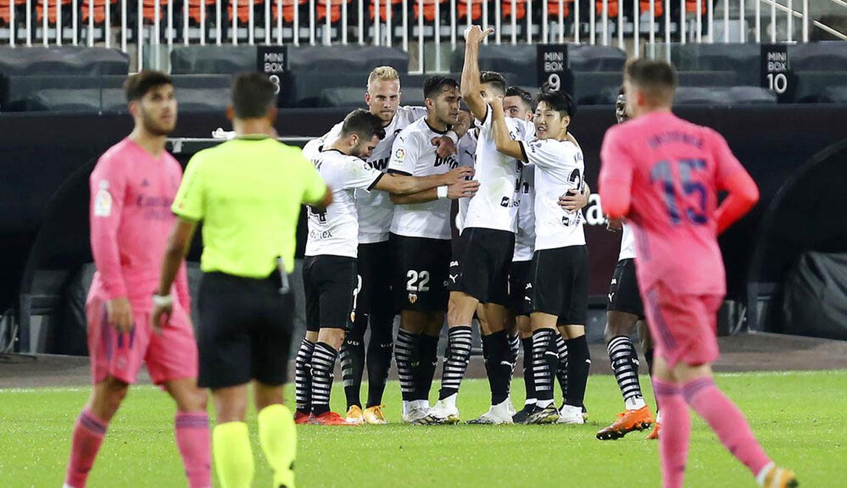 Para pemain Valencia merayakan gol yang dicetak ke gawang Real Madrid pada laga Liga Spanyol di Stadion Mestalla, Minggu (8/11/2020). Valencia menang dengan skor 4-1. (AP/Alberto Saiz)