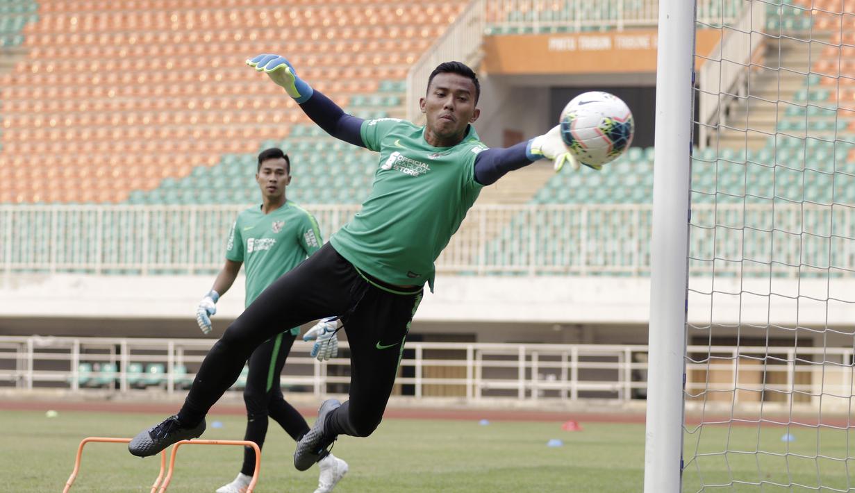 Kiper Timnas Indonesia, Teja Paku Alam, menepis bola saat berlatih di Stadion Pakansari, Bogor, Sabtu (24/8). Latihan ini merupakan persiapan jelang laga kualifikasi Piala Dunia 2020. (Bola.com/Yoppy Renato)