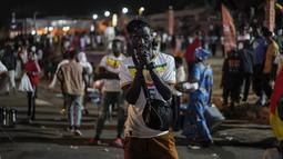 Reaksi suporter Senegal setelah menyaksikan laga babak 16 besar Piala Dunia 2022 saat tim kesayangan mereka melawan Inggris di Qatar, lewat layar video yang dipsang di fan zone di Dakar, Senin (5/12/2022) dini hari WIB. Senegal ditaklukkan Inggris dengan skor 0-3. (AP Photo/Leo Correa)