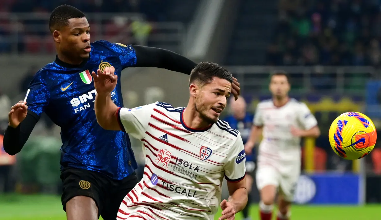 Bek Inter Milan Denzel Dumfries (kiri) berebut bola dengan bek Cagliari Andrea Carboni pada laga lanjutan Liga Italia pekan ke-17 di Guseppe Meazza, Senin dini hari WIB (13/12/2021). Inter Milan menang telak 4-0 atas tim tamu Cagliari. (Miguel MEDINA / AFP)