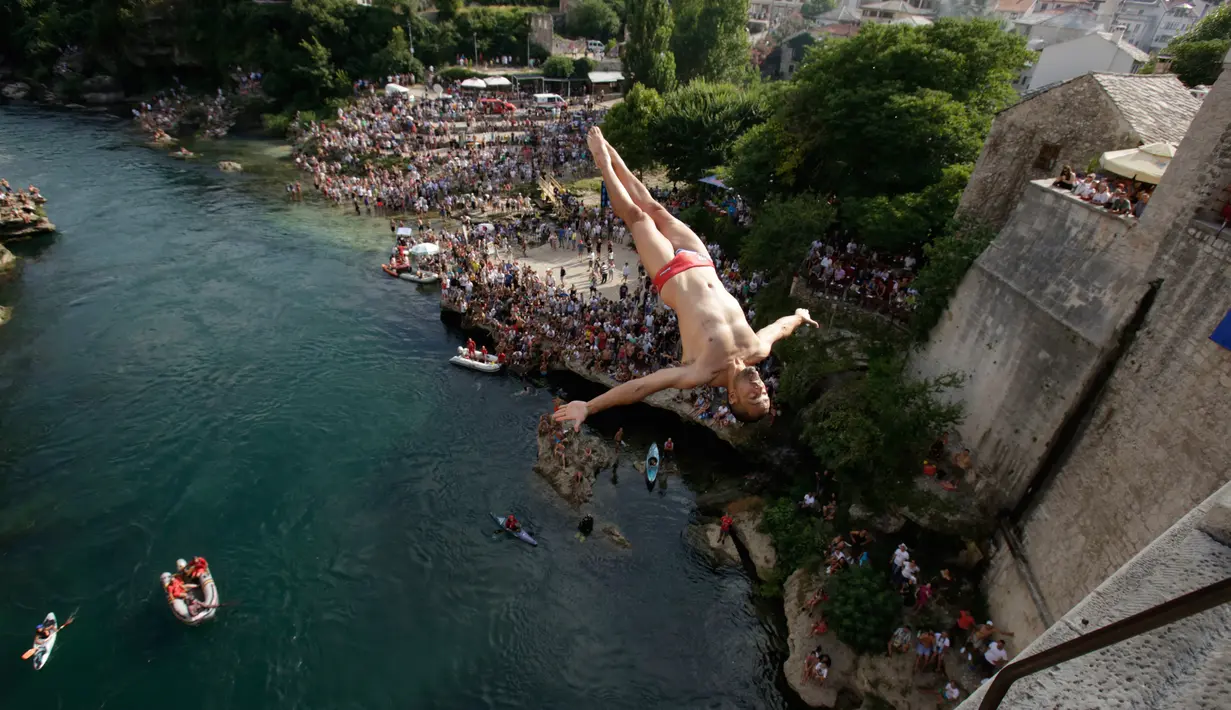 Peserta melompat dari Jembatan Old Mostar pada kompetisi menyelam tradisional ke-452 di Mostar, Bosnia, 29 Juli 2018. Sebanyak 40 penyelam dari Bosnia dan negara tetangga harus melompat dari jembatan setinggi 24 meter ke Sungai Neretva. (AP/Amel Emric)