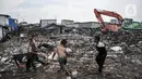 Anak-anak bermain dekat alat berat yang sedang membersihkan sampah di kawasan Kali Baru, Cilincing, Jakarta Utara, Rabu (23/2/2022). Lautan sampah mengepung permukiman padat penduduk di RW 04 dan 15 Kelurahan Kali Baru. (merdeka.com/Iqbal S. Nugroho)